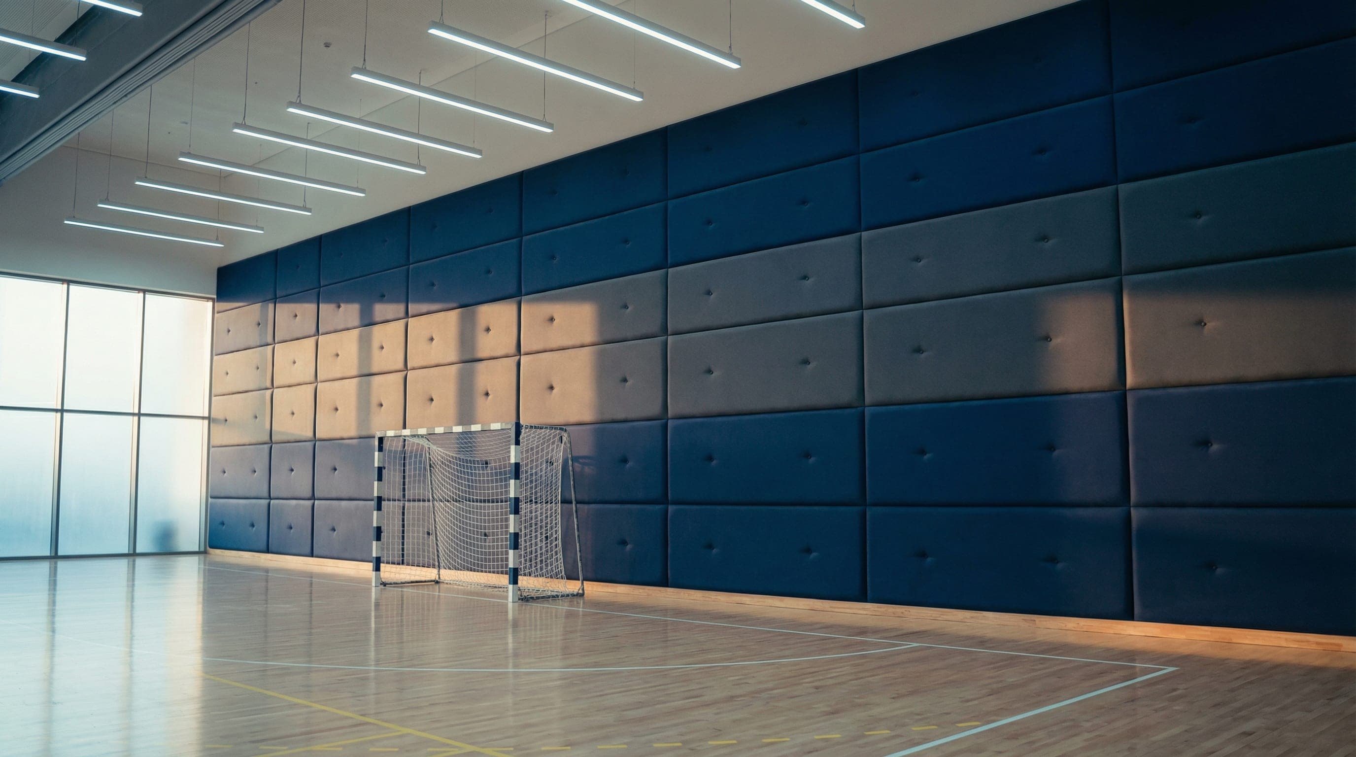 EN 14904 certified impact-resistant gymnasium safety wall panels supplied and installed by Ayana in Qatar.